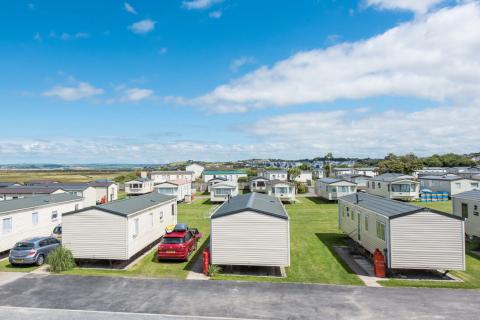 Holiday homes with the North Devon hills in the backgroundA row of holiday homes on a bright summers day with hills in the background
