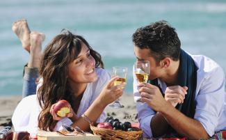 Couple drinking champagne on the beach